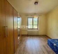 Pokoj v 2-pokojovém bytě s podlahou s dřevěným dekorem a vestavěnou skříní.