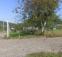 Pozemky na bydlení na ulici v Humenném s travnatým porostem a stromy.