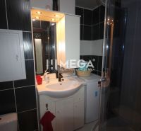 Koupelna v rekreačním apartmánu se sprchovým koutem, umyvadlem a pračkou.