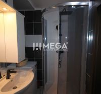 Koupelna v rekreačním apartmánu s umyvadlem, sprchovým koutem a zrcadlem s osvětlením.