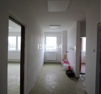 Chodba v kanceláři bez podlahy s dřevěným dekorem, připravená na renovaci.