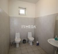 Toaleta v kanceláři se dvěma WC a umyvadlem, obložené bílé kachličky.