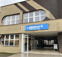 Exteriér kanceláří na Hlavní ulici ve Stropkově s dominantními oblými okny.