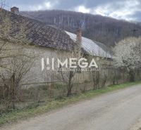 Rodinný dům na ulici Čabiny v Čabinách obklopený kvetoucími stromy a přírodou.