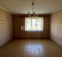 Pokoj s tapetami a podlahou s dřevěným dekorem v rodinném domě.