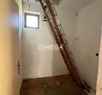 Žebřík vede na půdu v rodinném domě s podlahou s dřevěným dekorem.