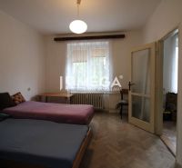 Ložnice s dvěma postelemi a podlahou s dřevěným dekorem v 2-pokojovém bytě.