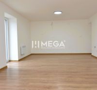 Prostorná místnost s podlahou s dřevěným dekorem v 2pokojovém bytě.