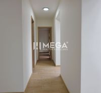 Chodba s bílými stěnami a podlahou s dřevěným dekorem v 2-pokojovém bytě.