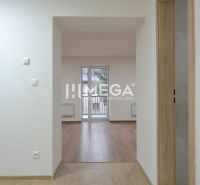 Interiér 3-pokojového bytu s podlahou s dřevěným dekorem, prosvětlený prostor s balkónovými dveřmi.