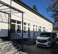 Budova s obchodními prostory na Tyršově ulici v Humenném, zaparkovaná auta, strom.