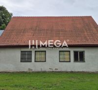 Obchodní prostory v Zboji se šikmou střechou a okny se zabudovanými mřížemi.