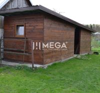 Dřevěná stavba u rodinného domu ve městě Krásný Brod na zelené trávě.