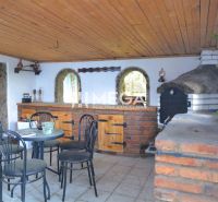 Rodinný dům s exteriérovým krytem a posezením, Koškovce, cihlové i dřevěné prvky architektury.