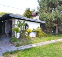 Exteriér rodinného domu v Koškovcích s terasou a bohatou zelení v zahradě.