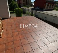 Terasa rodinného domu v Pčoliném na ulici Pčoliné s cihlovou dlažbou a dřevěnou lavičkou.