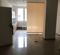 Interiér s dlažbou, kuchyňskou linkou a vertikálními žaluziemi v budově.