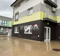 Obchodní prostory na Komenského ulici v Snině s moderní fasádou a balkónem.