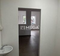 Interiér obchodních prostor s umyvadlem a dveřmi, podlaha s dřevěným dekorem.