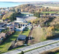 Panoramatický výhled na pozemky k bydlení ve Vinném s blízkým jezerem.