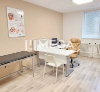 Lékařské ordinace s kancelářským nábytkem, křesly a podlahou s dřevěným dekorem.