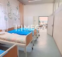 Interiér s nemocničními postelemi a hygienickým filtrem v obchodních prostorách.