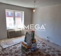 Prázdný pokoj v 2-pokojovém bytě s materiály na renovaci.