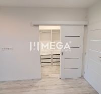 Interiér rodinného domu s bílými posuvnými dveřmi a podlahou s dřevěným dekorem.