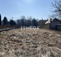 Pozemky - bydlení v Modre nad Cirochou s travnatou plochou a viditelnými budovami.