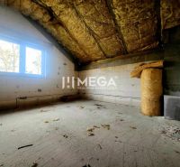 Interiér rodinného domu s nedokončenou místností a izolačním materiálem na podlaze.