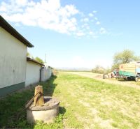 Exteriér v Sačurově pro Pozemky - bydlení s budovou, zemědělským strojem a studnou.