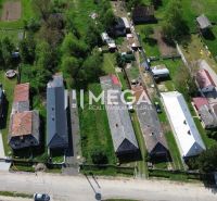 Letecký pohled na pozemky k bydlení v Sennom se zahradami a domy.