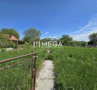 Pozemky - bydlení ve Velké Idě, Gomboši s travnatou plochou a venkovským domem.