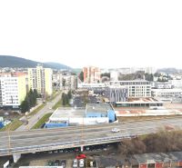 Město Humenné, ulice Štefánikova, zobrazuje výhled na obchodní prostory a dálnici.
