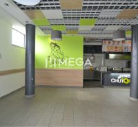 Interiér obchodních prostor s výzdobou na stěnách a otevřenou kuchyní.
