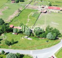 Pozemky - bydlení v Ptičom, obklopené zelení u hlavní silnice.