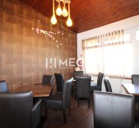 Gastro prostory s pohodlnými židlemi a podlahou s dřevěným dekorem.