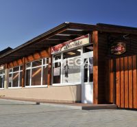 Gastro prostory na Budovatelské ulici ve Vranově nad Topľou s dřevěným venkovním obkladem.