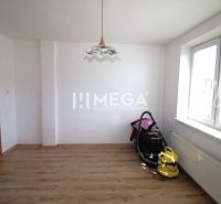 Interiér rodinného domu s bílými stěnami a podlahou s dřevěným dekorem.