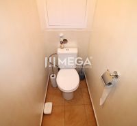Koupelna s toaletou a jednoduchými doplňky ve 4-pokojovém bytě.