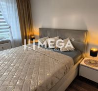 Ložnice v 3-pokojovém bytě s postelí, nočními stolky a podlahou s dřevěným dekorem.