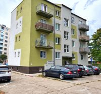 Bytový dům na Andrusovově ulici, Bratislava - Petržalka se zaparkovanými auty před budovou.