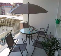 Balkon 3pokojového bytu Nad Plážou v Banské Bystrici s posezením a slunečníkem.