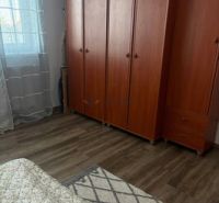 Pokoj v 2-pokojovém bytě se skříněmi a podlahou s dřevěným dekorem.