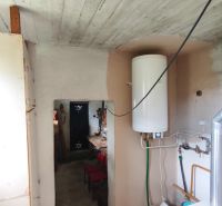 Koupelna v rodinném domě s bojlerem a kotelnou, dlažba na podlaze.
