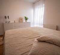 Ložnice s bílým nábytkem a dekorativními doplňky v rodinném domě.