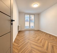 Pokoj v 3-pokojovém bytě s podlahou s dřevěným dekorem a francouzským oknem.