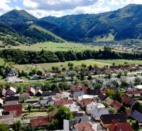 Malebná panoráma Švošova zobrazující rozmanité Pozemky - bydlení s kopcovitým pozadím.