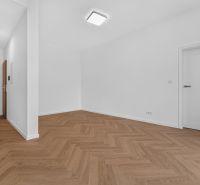 Bílý interiér 3-pokojového bytu s podlahou s dřevěným dekorem a moderním osvětlením.