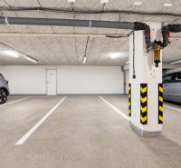 Podzemní parkoviště s parkovacími místy a automobily.